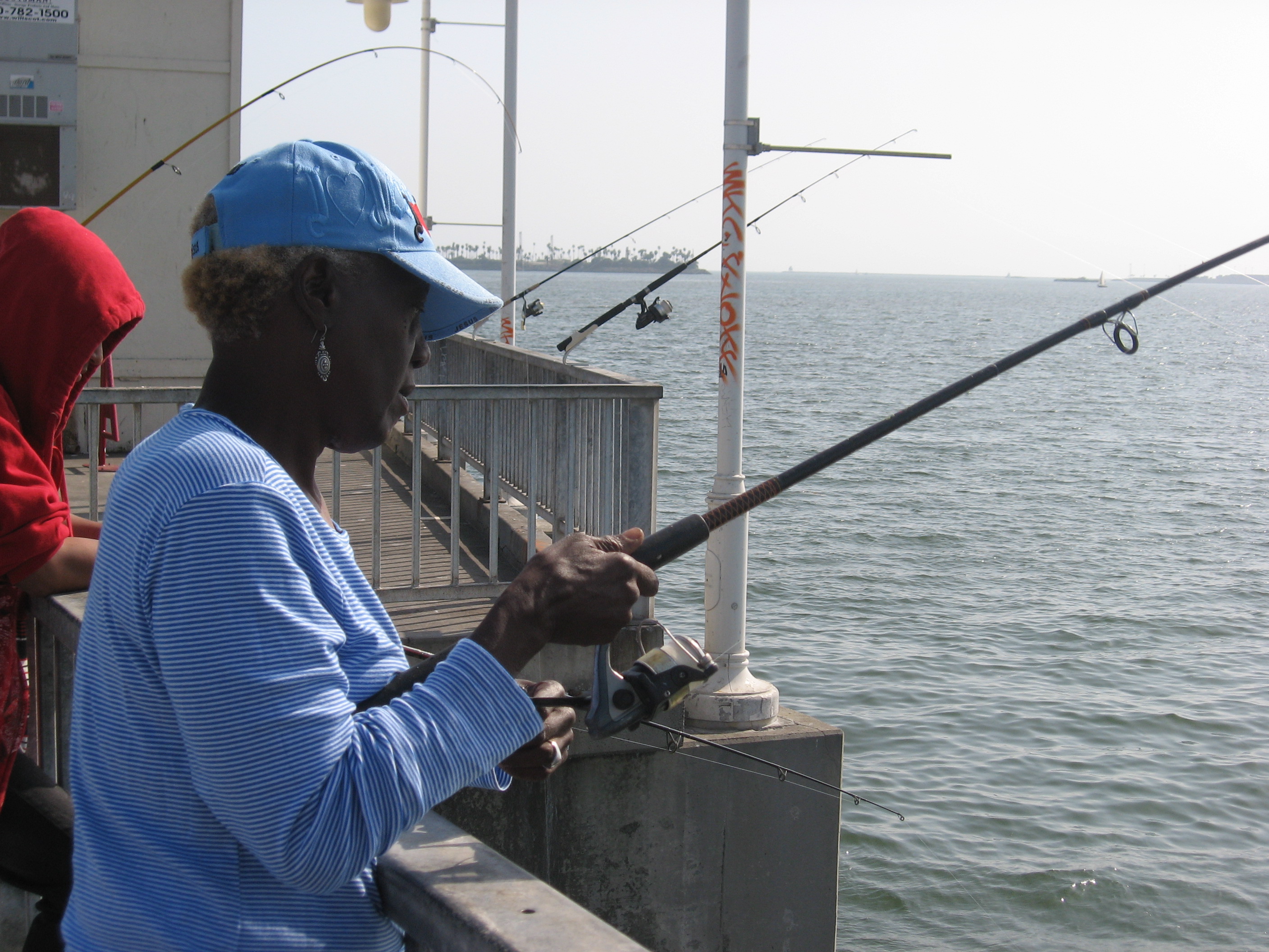 Deborah White of Fontana fishes on a recent Saturday afternoon at the Belmont Veterans Memorial Pier in Long Beach. Outreach programs have helped White and other anglers learn about the dangers of contaminated fish.